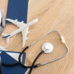 Medical tourism concept. Stethoscope with passport and tickets, toy plane